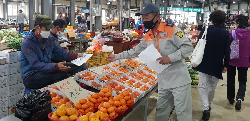 전통시장에서 의용소방대원들이 화재예방 및 소화전 주변 불법 주,정차 홍보 전단지를 상인 및 지역 주민들에게 돌리고 있다.