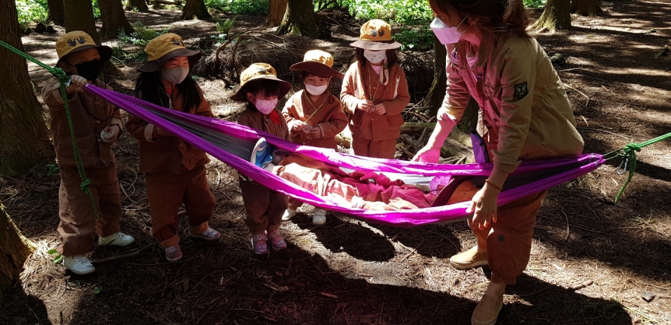 유아 숲 지도자와 함께 애벌레 모습을 취하고 있는 어린이집 원생들 모습(사진 고기봉 기자)