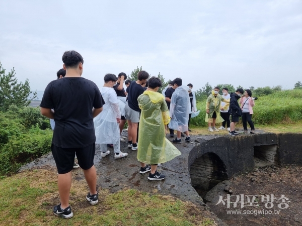 섯알오름 고사포진지에서 해설사 해설을 들으면서 역사를 배우는 청소년들