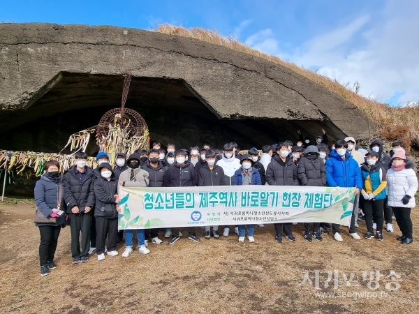 제주역사 바로알기 체험현장 알뜨르비행장격납고 탐방에 나선 청소년들이 기념촬영을 하고 있다.