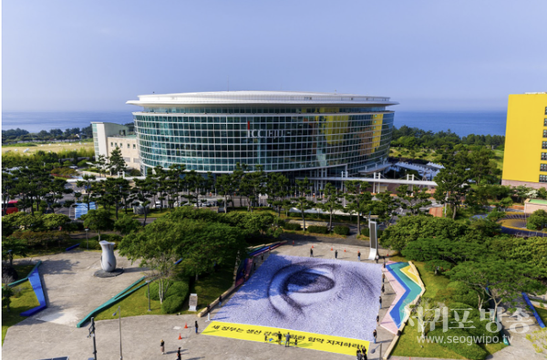 플뿌리연대는 ‘2025 세계 환경의 날’ 기념 행사가 시작된 4일 오전 국제컨벤션센터 앞에서 ‘강력한 플라스틱 협약’을 요구하기 위해 눈이 그려진 #WeAreWatchin 초대형 깃발을 펼치는 퍼포먼스를 진행했다. 사진=그린피스 제공